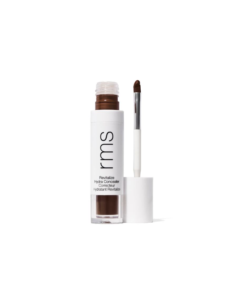 Open tube of Revitalize Hydra Concealer with applicator showing rich medium brown cream formula in white sleek packaging by RMS Beauty, highlighting clean beauty and skincare infused makeup.