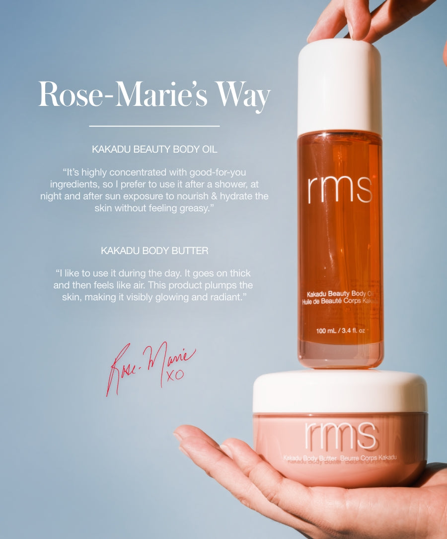 Hand holding a bottle and jar of Kakadu Body Oil and body butter by RMS Beauty against a light blue background, showcasing skincare products with clean ingredients and sustainable packaging.
