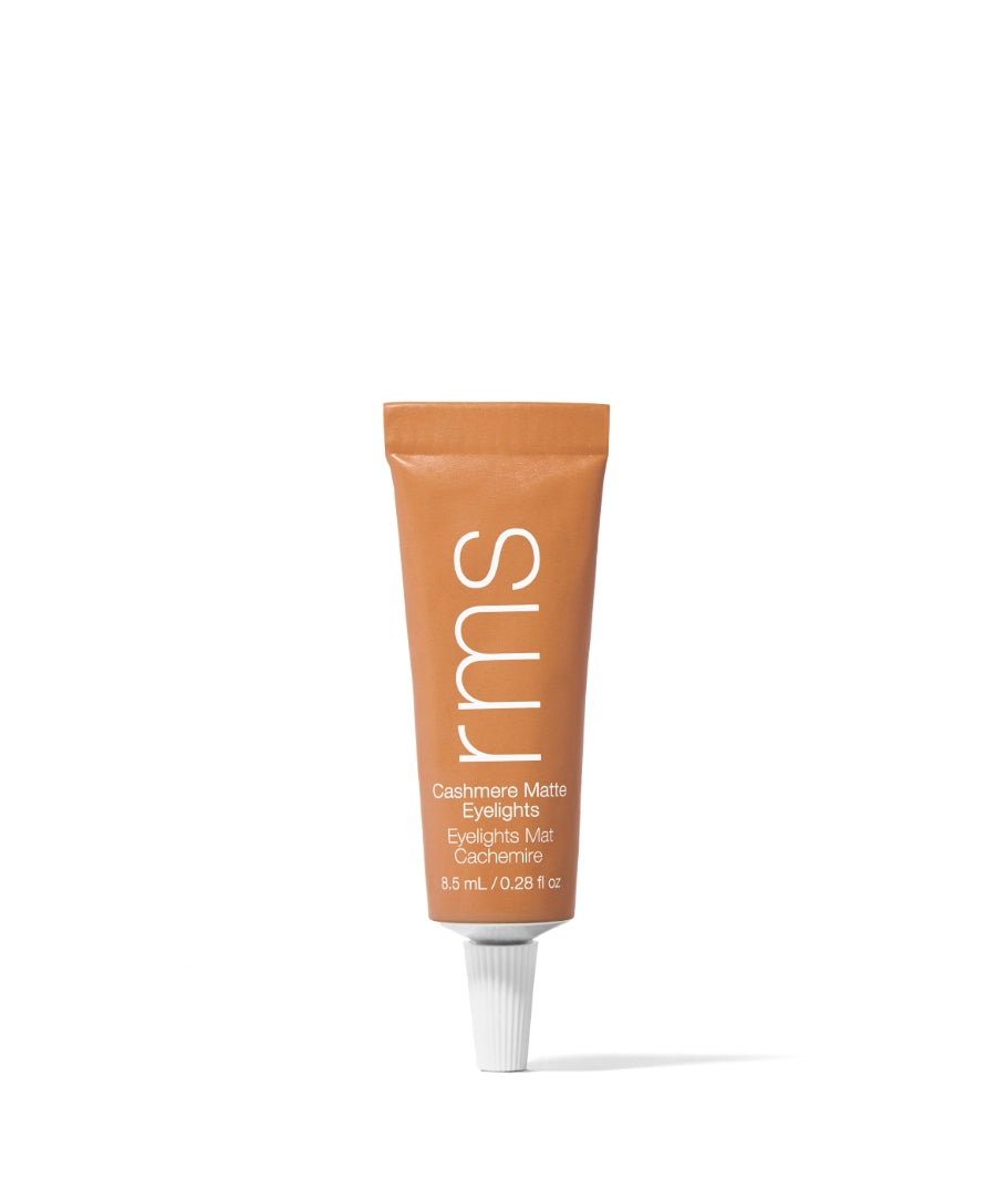 A small matte tan tube of Cashmere Matte Eyelights by RMS Beauty, featuring clean beauty and natural ingredients for a subtle, sustainable makeup glow.