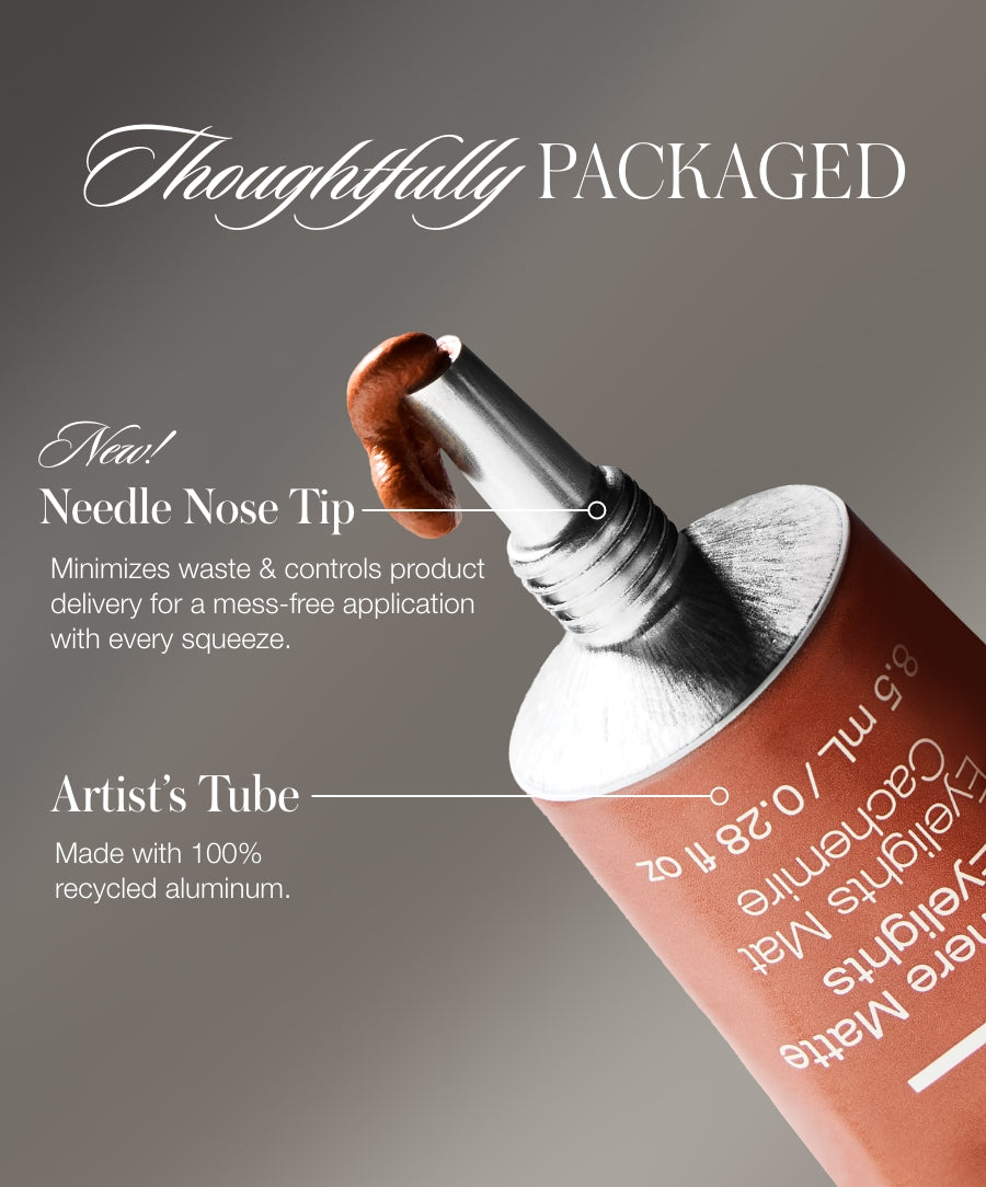 Close-up of a Cashmere Matte Eyelights tube with a needle nose tip dispensing creamy product, highlighting the artist’s tube made from 100% recycled aluminum.
