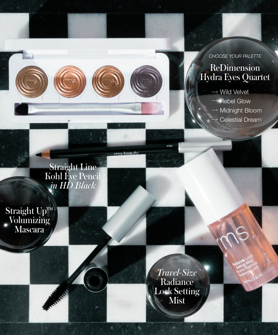 The Signature Artistry Set featuring an eyeshadow palette with warm and cool tones, a black kohl eye pencil, volumizing mascara, and travel-size radiance look setting mist on a checkered background.