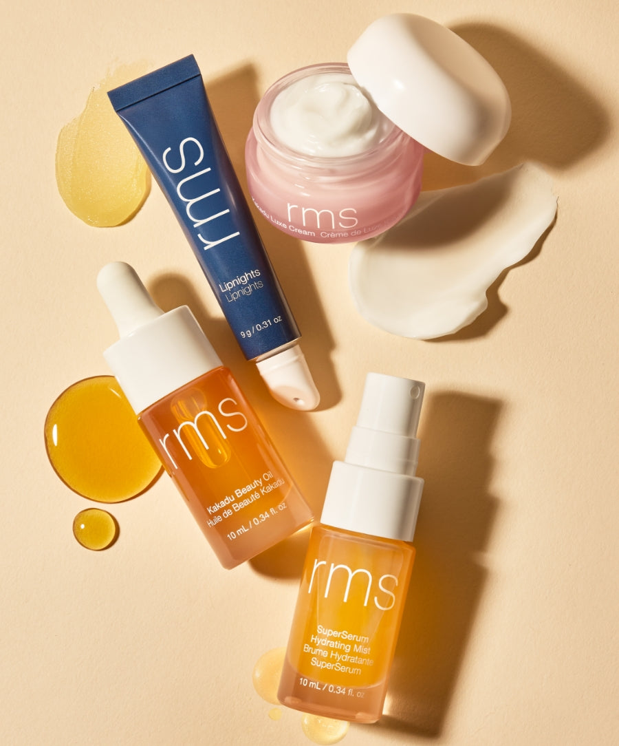 Skincare Secrets Travel Kit featuring RMS Beauty products with clean ingredients, including a lip treatment, moisturizing cream, beauty oil, and hydrating mist displayed with product textures on a beige background.