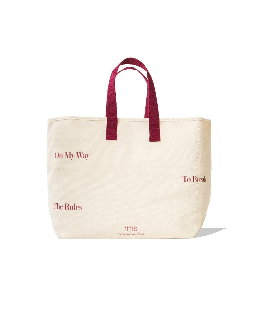 The Weekender Travel Tote in cream canvas with maroon handles featuring printed motivational text and a minimalist design for stylish, sustainable travel.