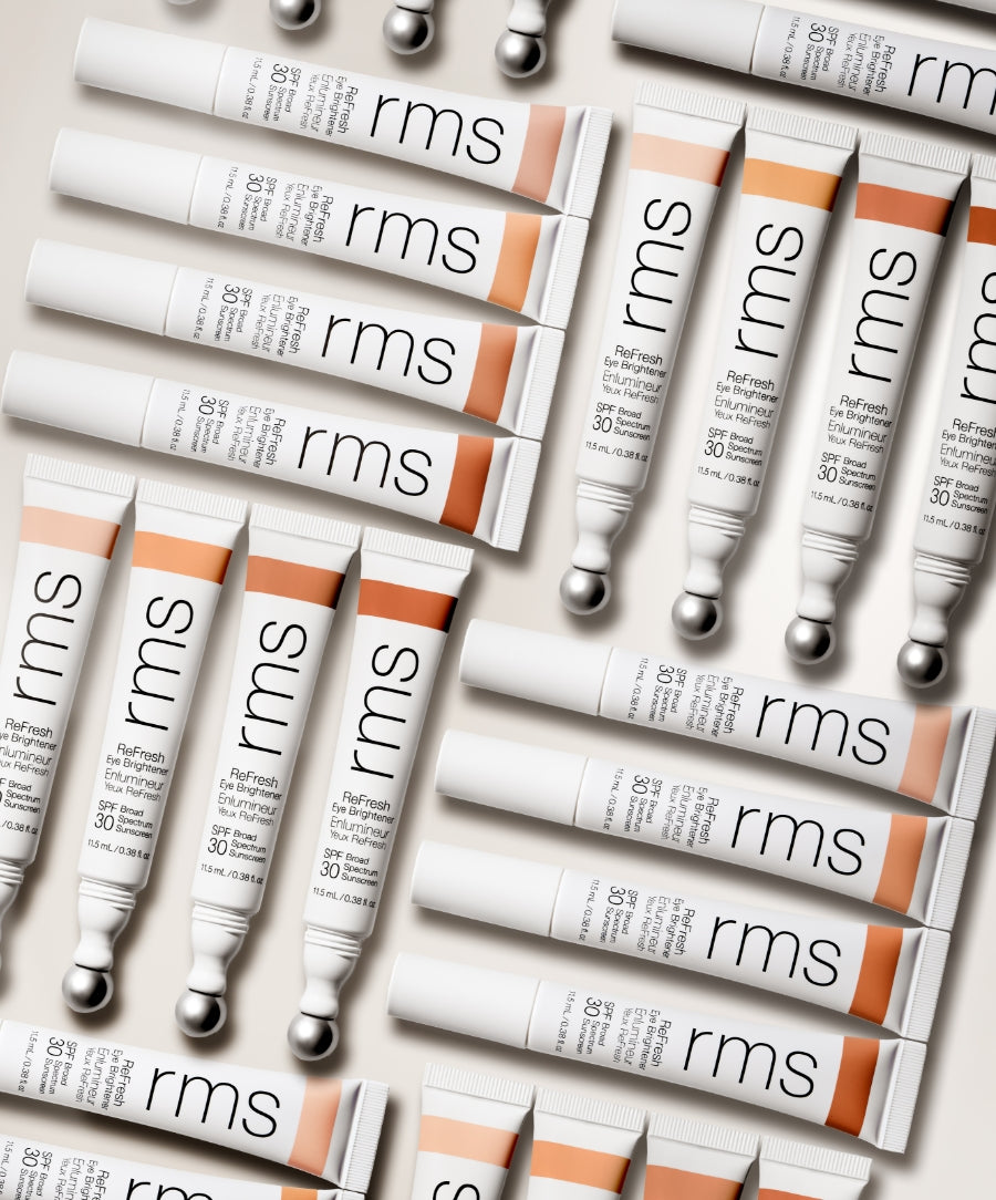 Multiple tubes of ReFresh Eye Brightener Broad Spectrum SPF 30 + Correcting Tint from RMS Beauty arranged on a light background, showcasing clean beauty packaging and natural tinted shades.