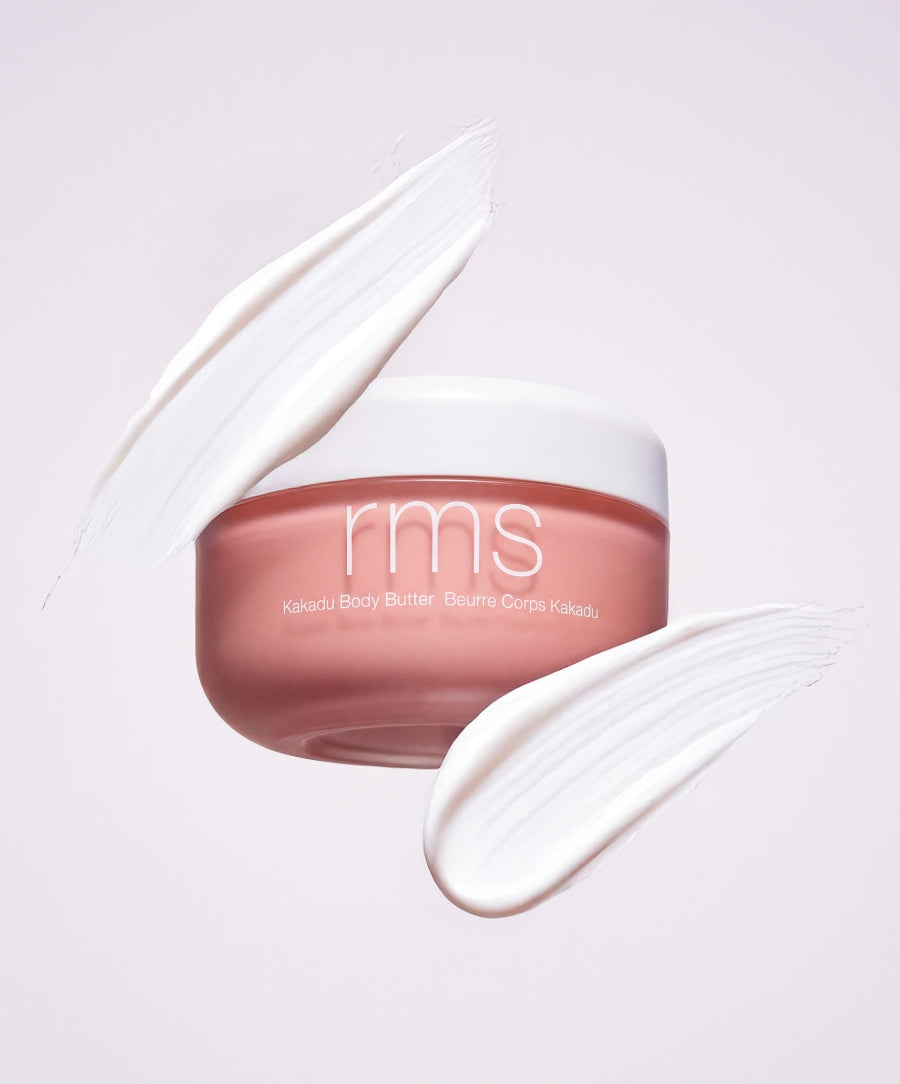RMS Beauty Kakadu Body Butter in a pink jar with white lid surrounded by creamy white swatches, showcasing clean beauty and natural skincare ingredients.