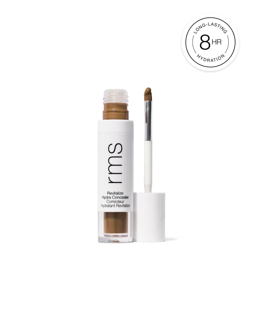 Open tube of Revitalize Hydra Concealer with applicator dipped in medium beige concealer shade, highlighting long-lasting 8-hour hydration and clean beauty features.