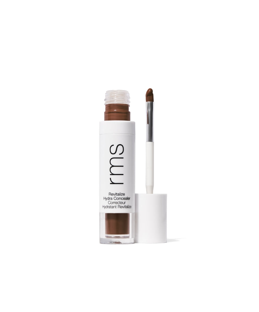 Open tube of Revitalize Hydra Concealer with applicator wand showing rich brown concealer cream, presented in sleek white and clear packaging.