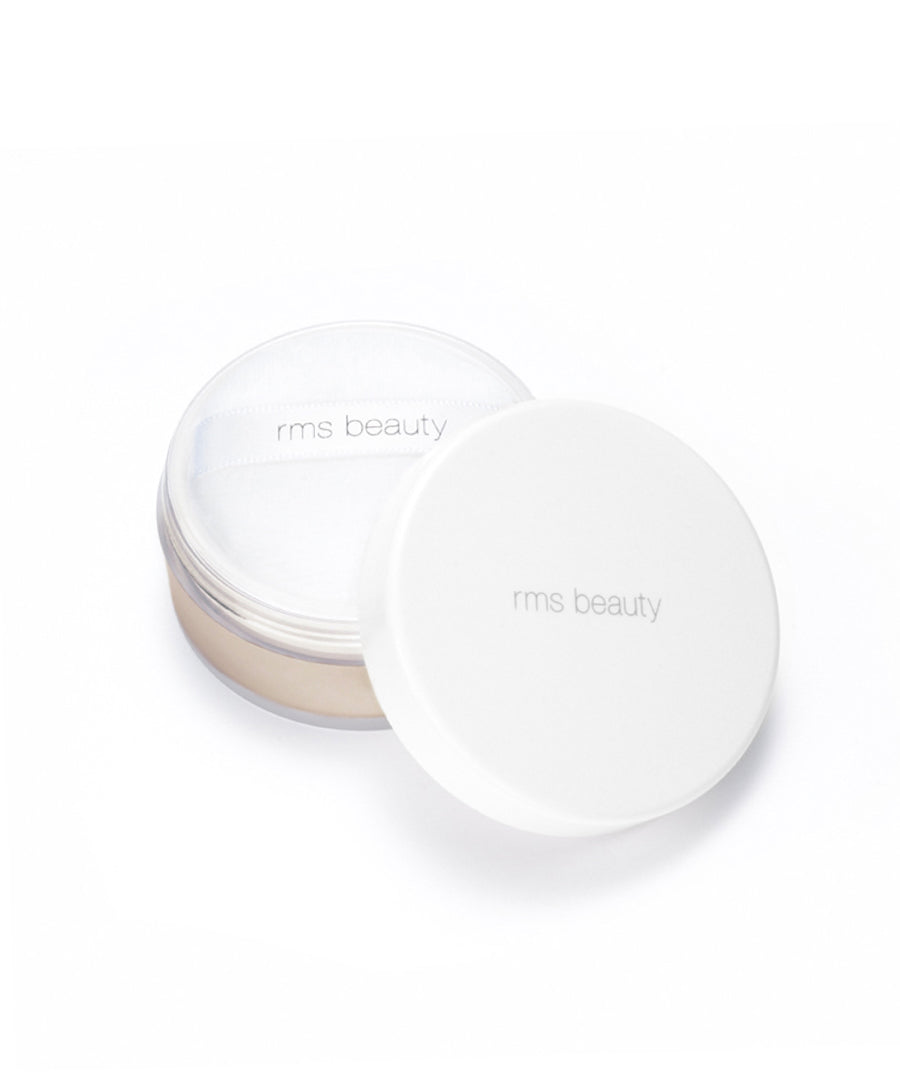 Open container of Tinted UnPowder loose setting powder from RMS Beauty with a white lid and included soft powder puff on a white background, showcasing clean beauty and natural ingredients.