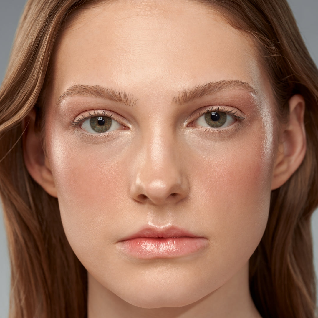 Close-up of a woman with natural makeup showcasing clear, healthy skin and subtle blush, emphasizing clean beauty and skincare infused makeup.