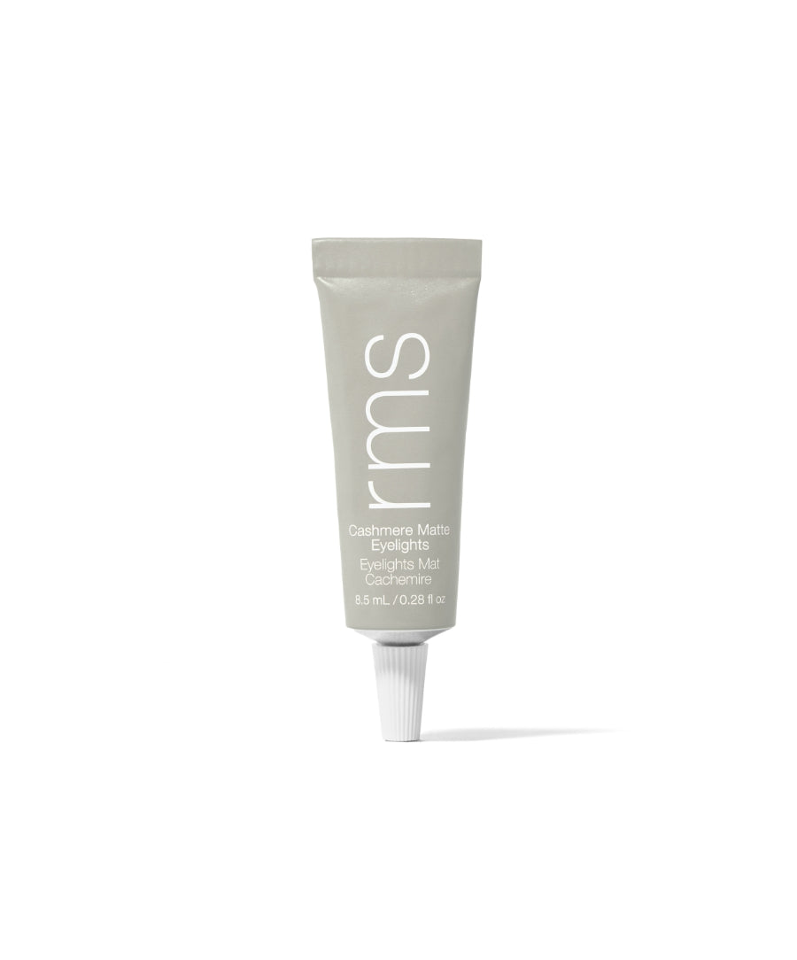 Tube of Cashmere Matte Eyelights makeup in a muted gray-green shade with clean beauty and natural ingredients branding visible on minimalist packaging.