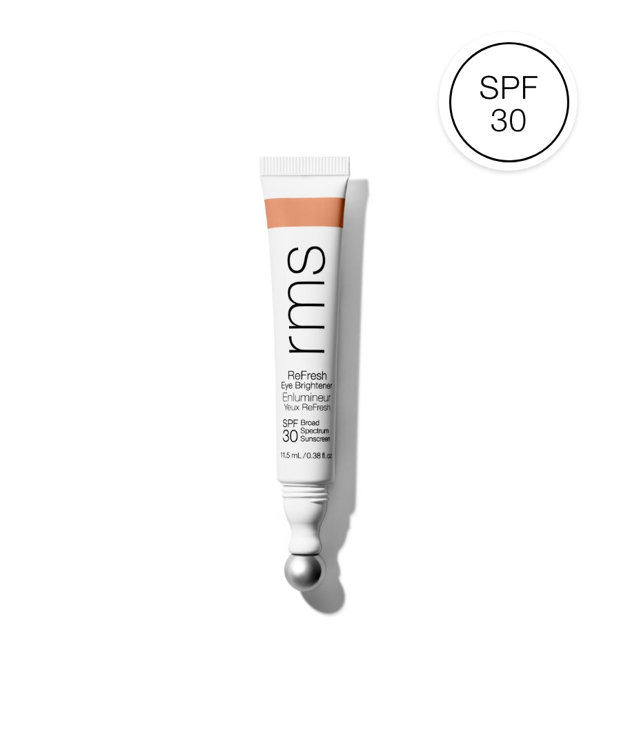 Tube of ReFresh Eye Brightener Broad Spectrum SPF 30 + Correcting Tint by RMS Beauty with a soft peach tint and built-in metal applicator ball, highlighting clean beauty and skincare infused makeup.