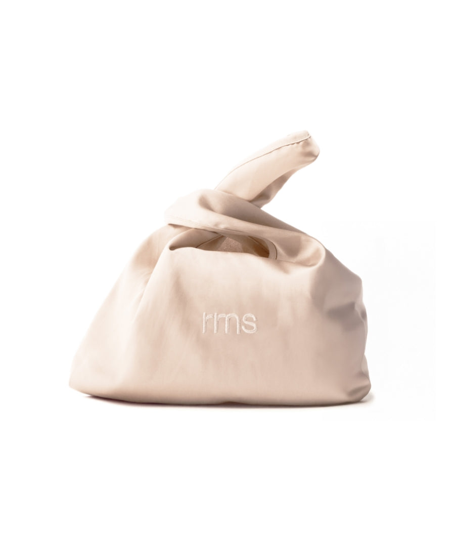The Silky Makeup Bag in a soft beige color with a smooth, silky texture and subtle "rms" embroidery, designed for clean beauty and sustainable makeup storage.