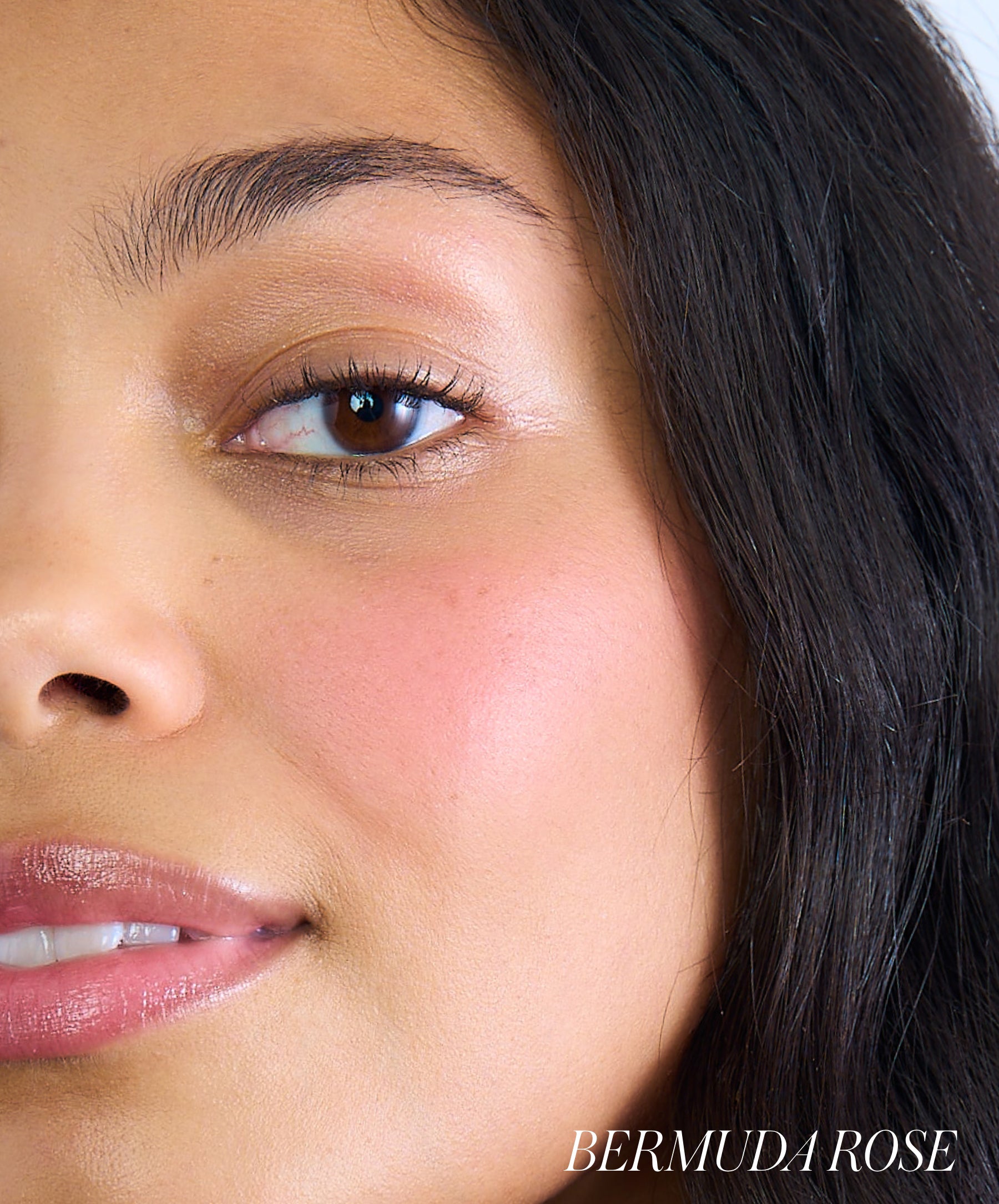 Close-up of a woman’s face showcasing soft pink cheeks enhanced with ReDimension Hydra Powder Blush, highlighting a natural, radiant look with clean beauty appeal.