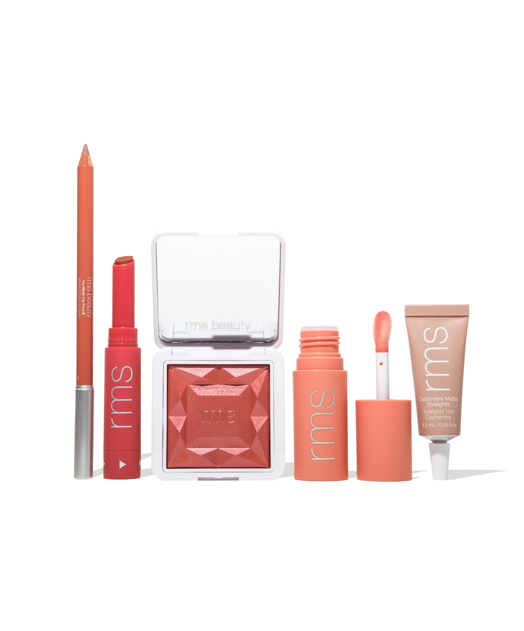 A set of clean beauty makeup products in coral and peach tones including a lip liner, lipstick, blush, lip gloss, and tinted moisturizer from the Color Capsule: The Summer Sangria Edit collection.