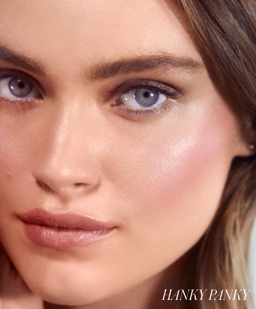 Close-up of a woman with subtle pink cheeks and natural makeup, showcasing the glowing finish of ReDimension Hydra Powder Blush for a fresh, radiant look.