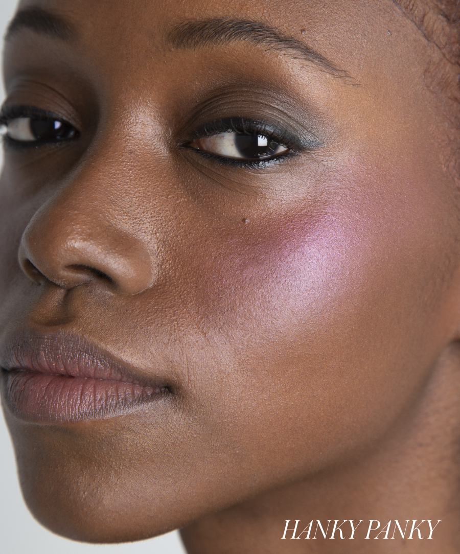 Close-up of a woman with smooth skin wearing ReDimension Hydra Powder Blush on her cheek, showcasing a soft, natural-looking pink glow and clean beauty makeup.