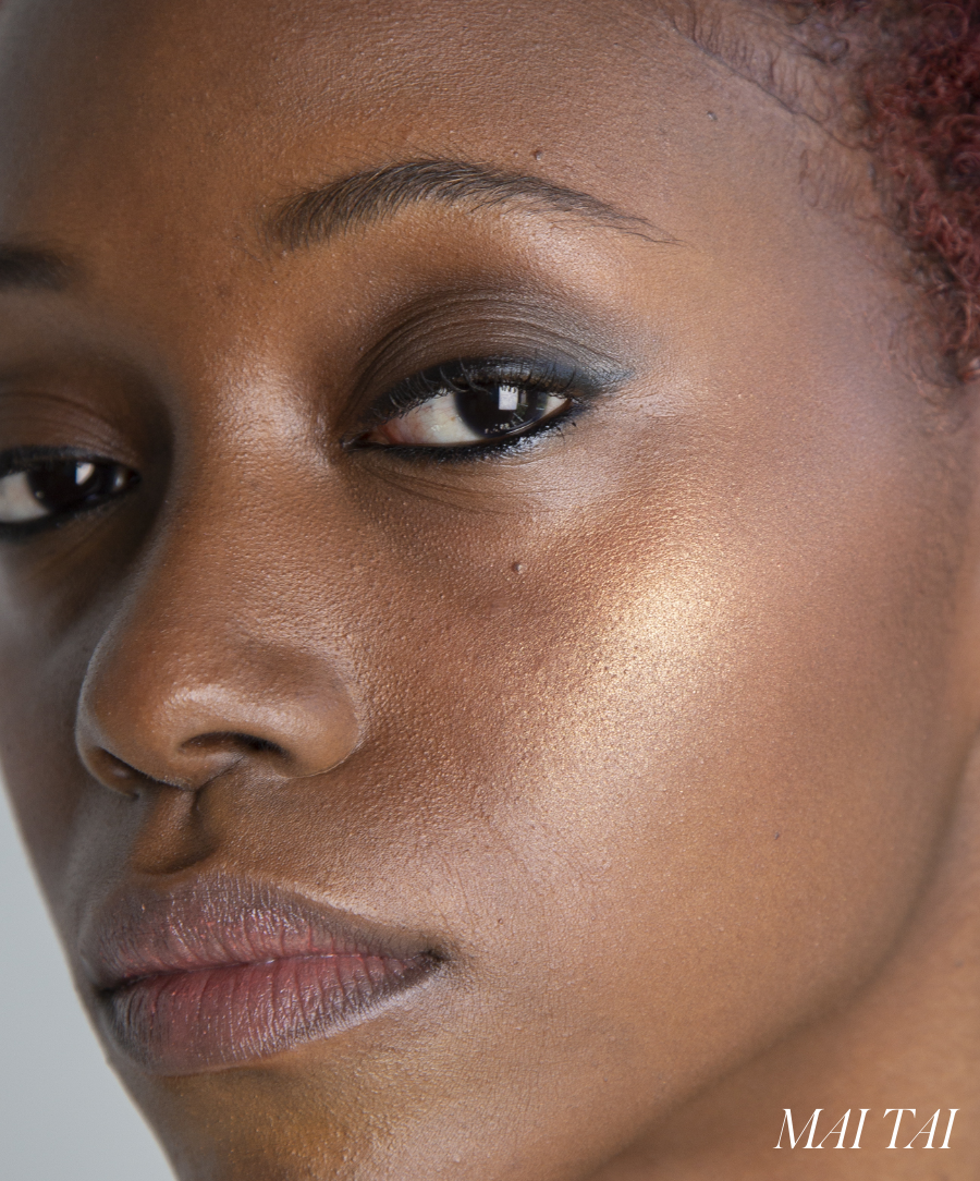 Close-up of a woman's face showcasing natural skin texture and subtle makeup highlighting the cheek with ReDimension Hydra Powder Blush in a warm, golden tone.