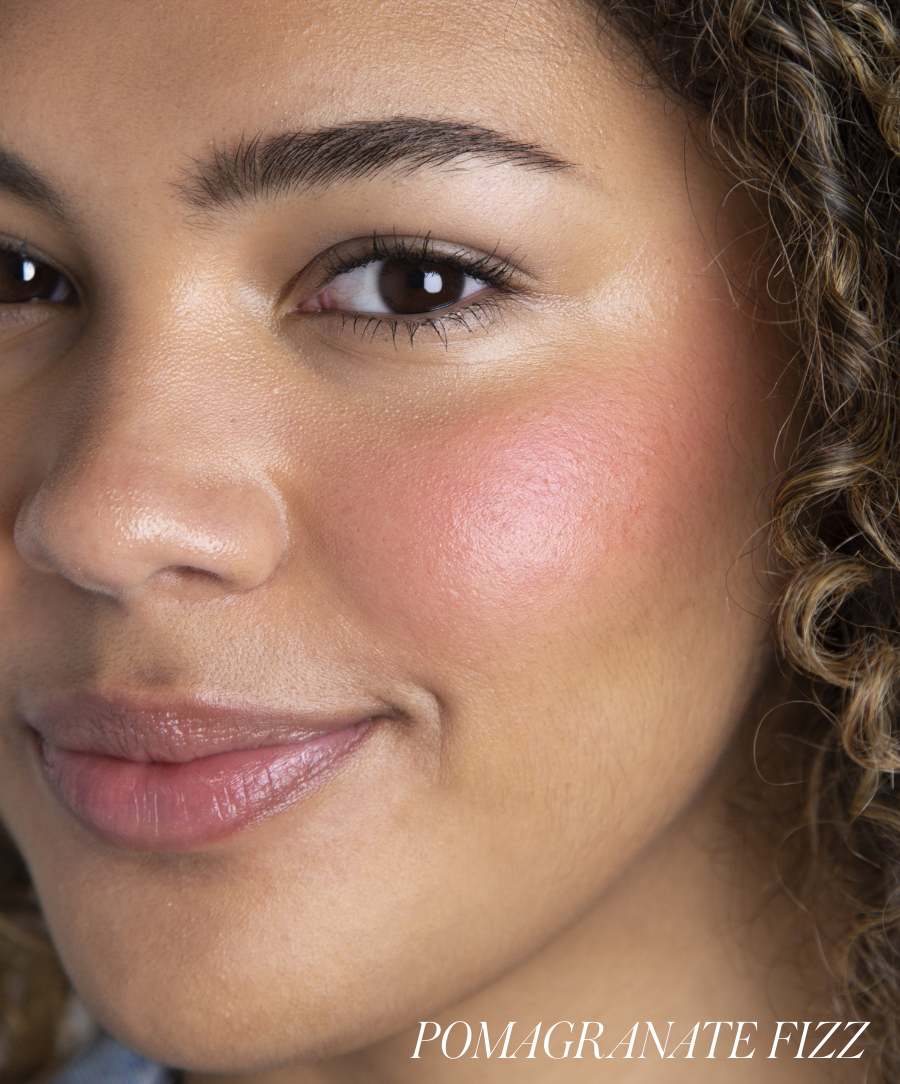Close-up of a woman smiling with natural makeup showcasing softly blended pink blush on her cheek, highlighting the radiant finish of ReDimension Hydra Powder Blush.