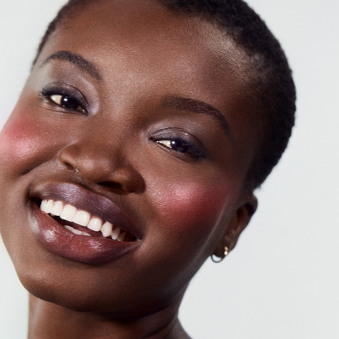 Close-up of a smiling woman with radiant skin wearing ReDimension Hydra Powder Blush featuring natural ingredients and clean beauty for a fresh, glowing look.